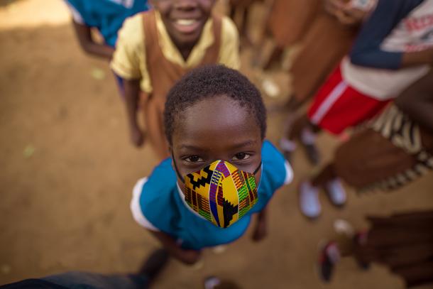 School child smiling with his eyes wearing a mask